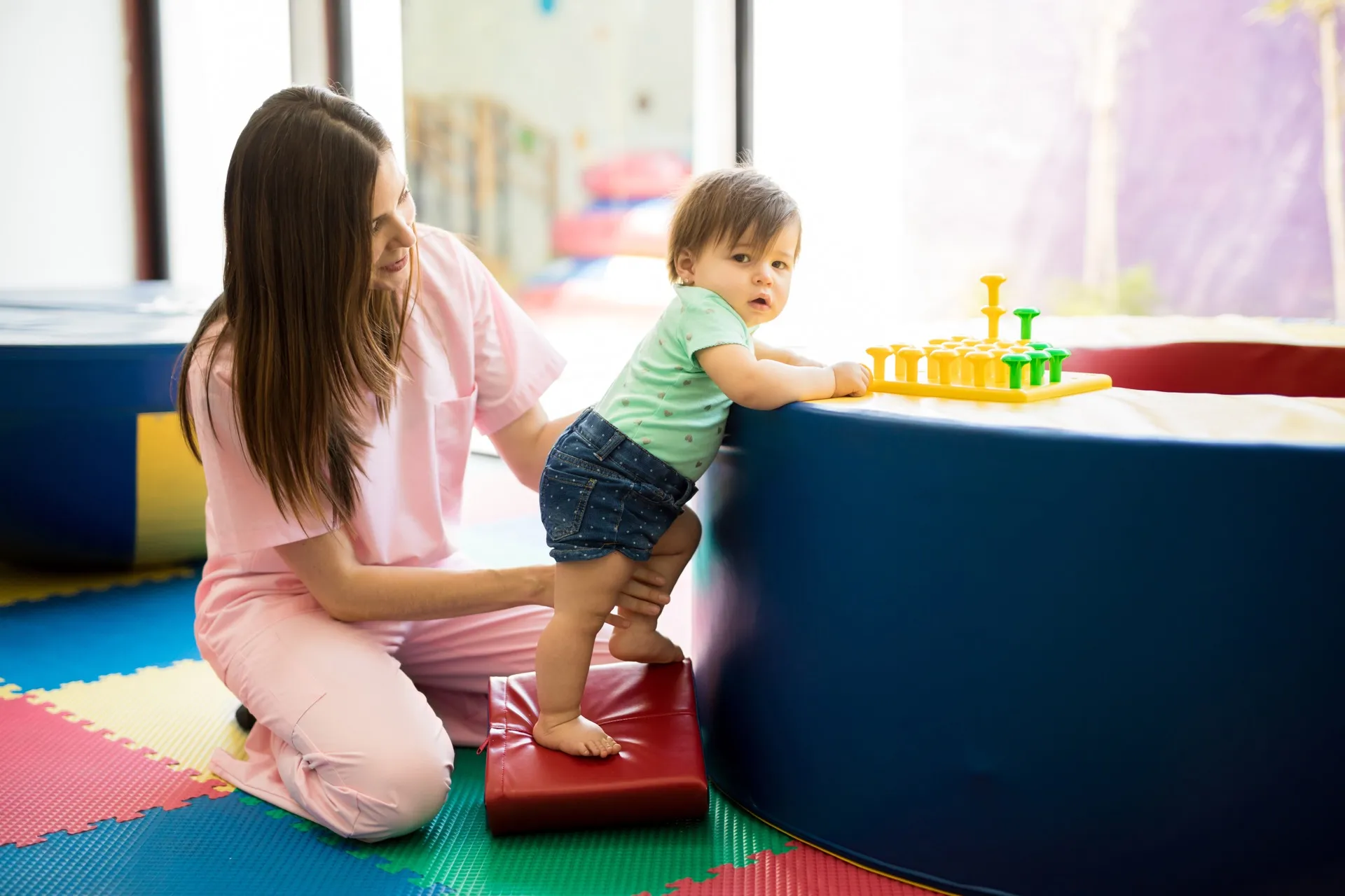 Therapist helping toddler practice standing